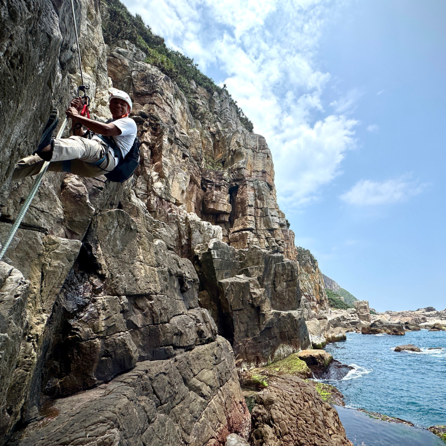 Practicing rappelling on rock face