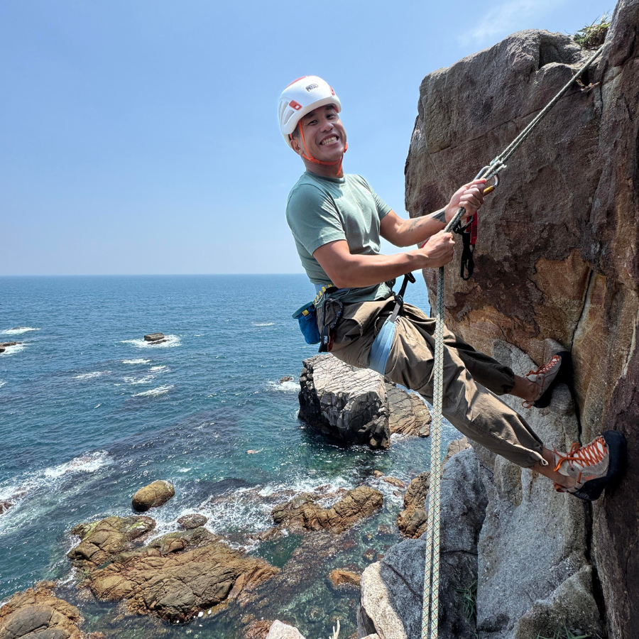 Climber reaching summit on a multi-pitch Longdong climb