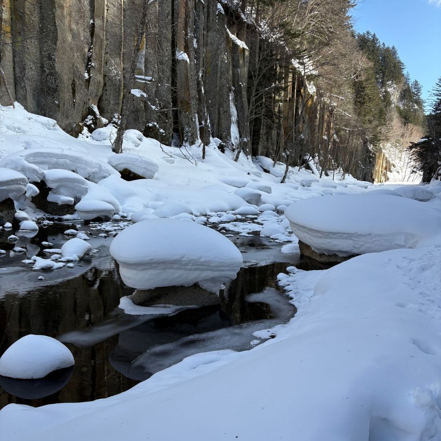 snow bubbles forming on rocks in frozen river Hokkaido